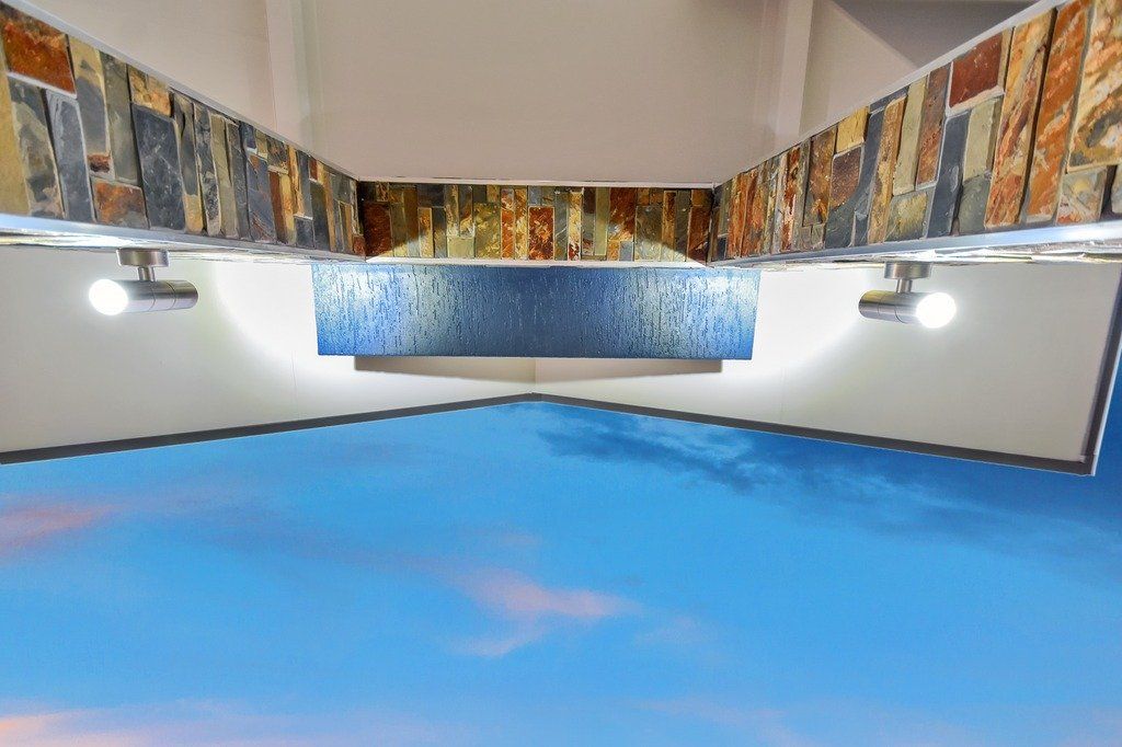 A room with a painting on the wall and a blue floor.