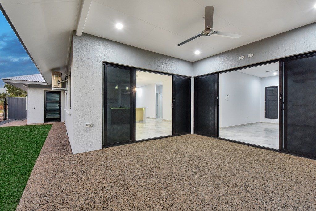 A large patio with sliding glass doors and a ceiling fan.