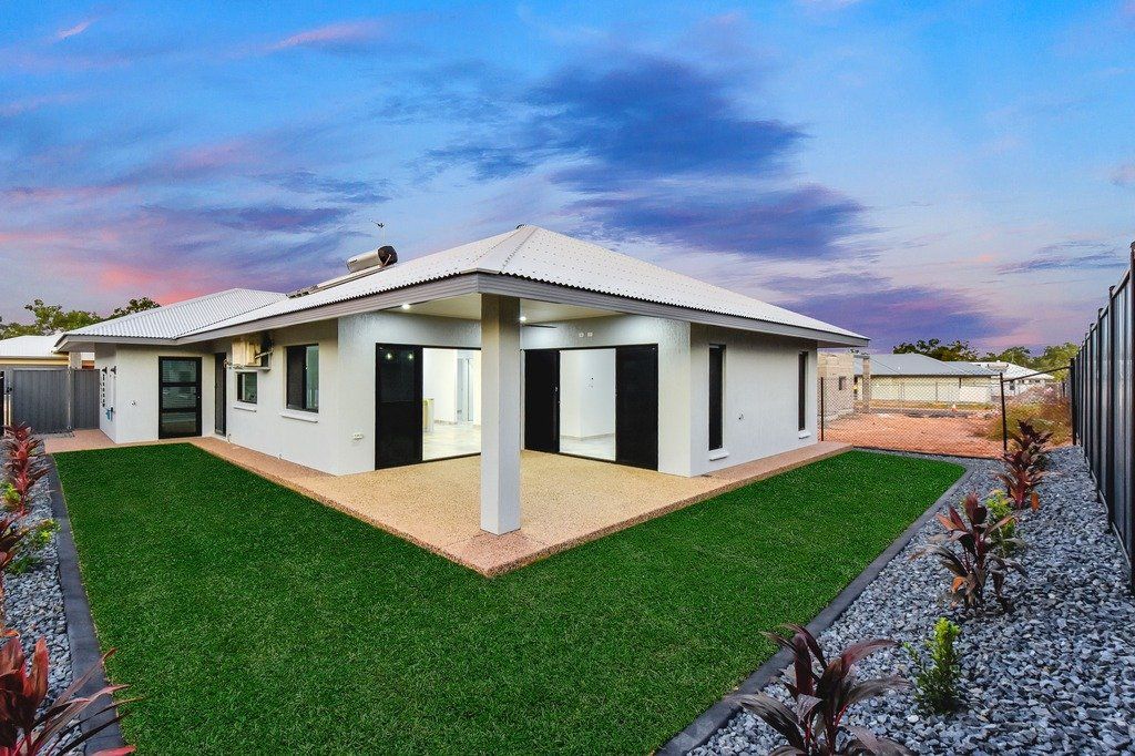A large white house with a large lawn in front of it.