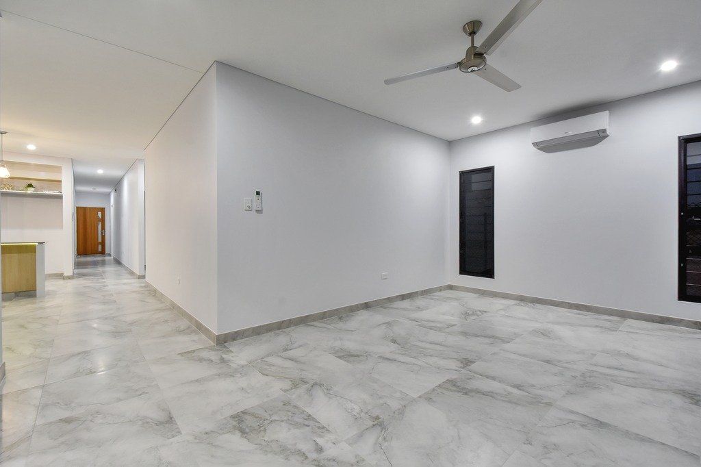 An empty room with white walls and a ceiling fan