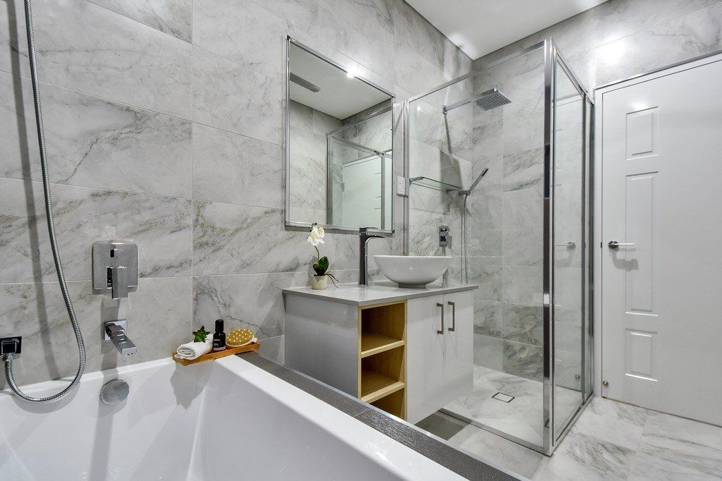 A bathroom with a bathtub , sink , mirror and walk in shower.