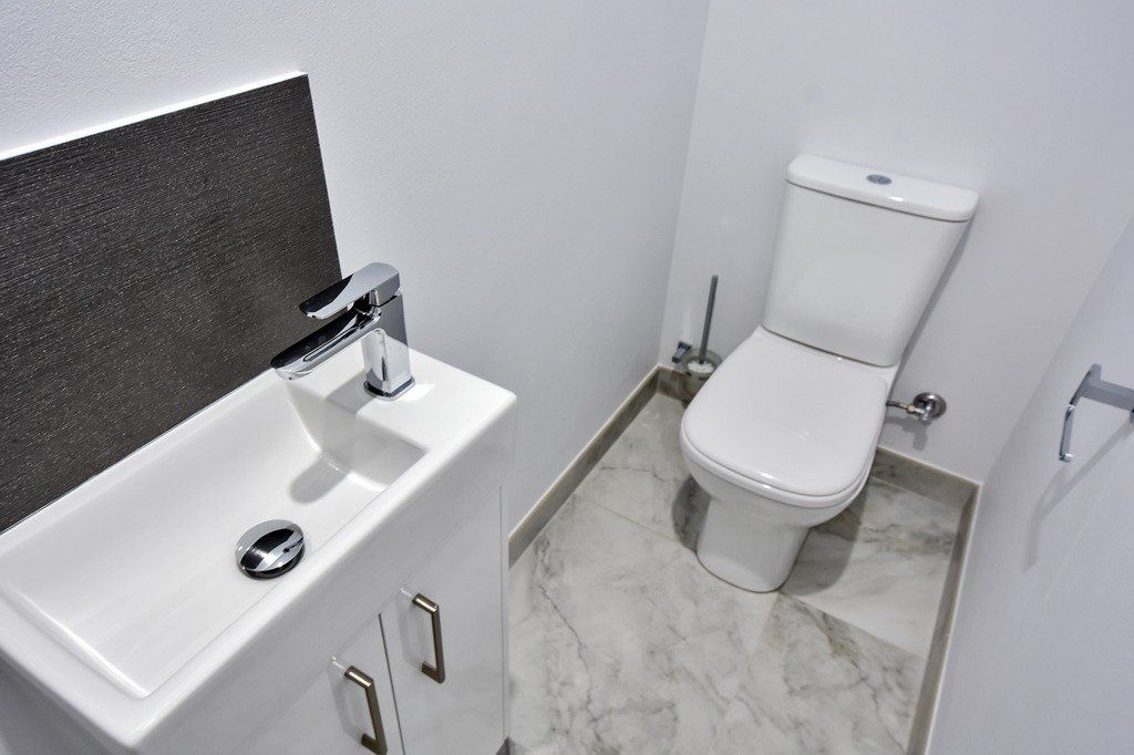 A bathroom with a toilet , sink and faucet