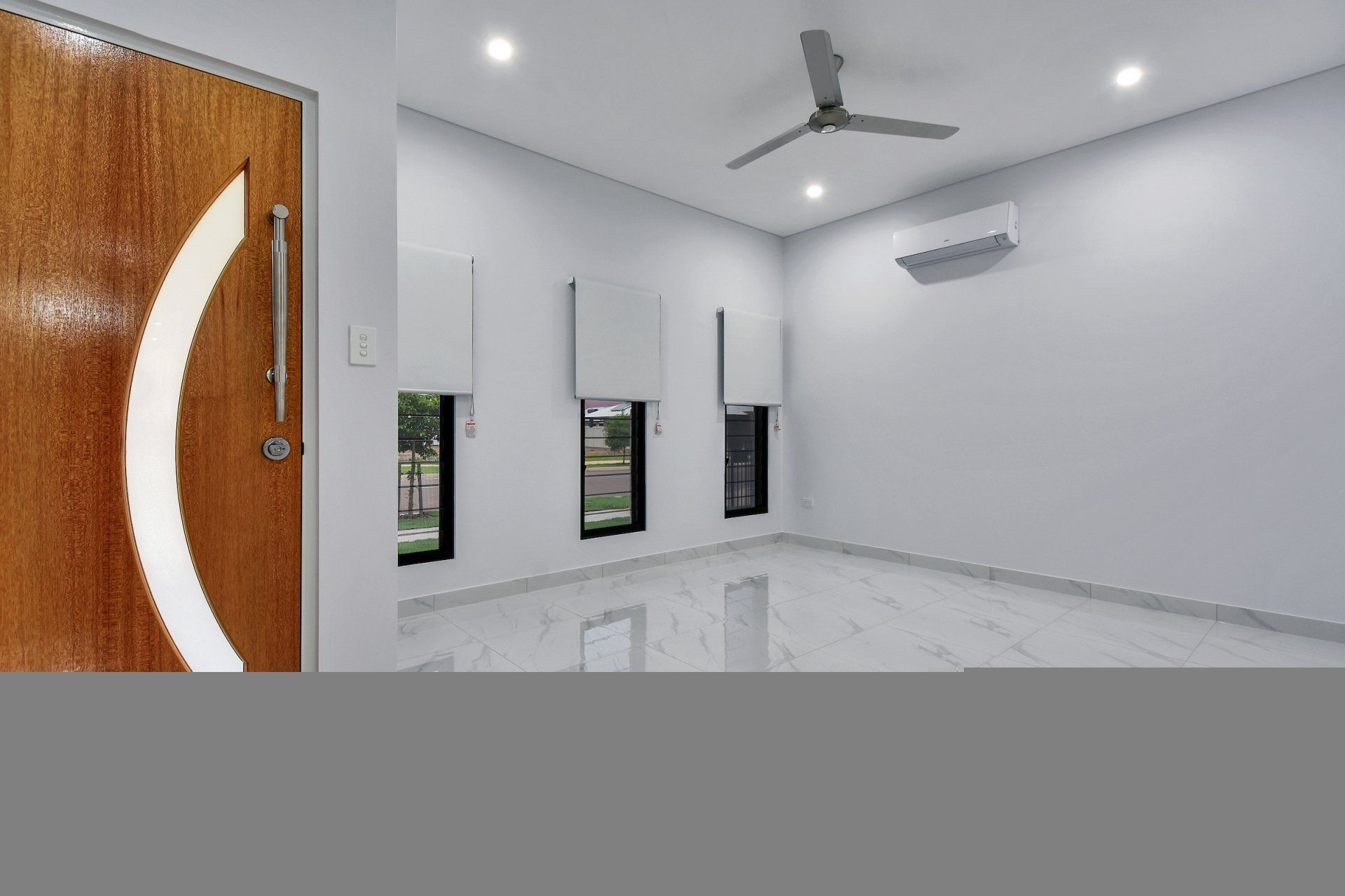 An empty room with a wooden door and a ceiling fan