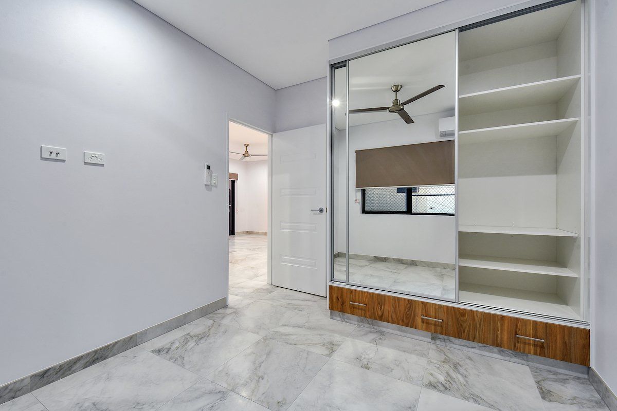 A bedroom with a ceiling fan and sliding glass doors.