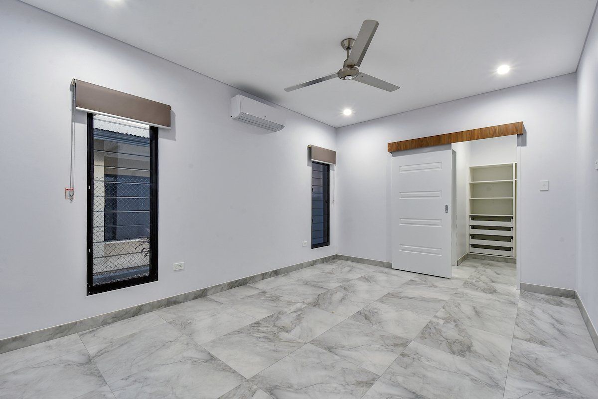 An empty bedroom with a ceiling fan and a walk in closet.