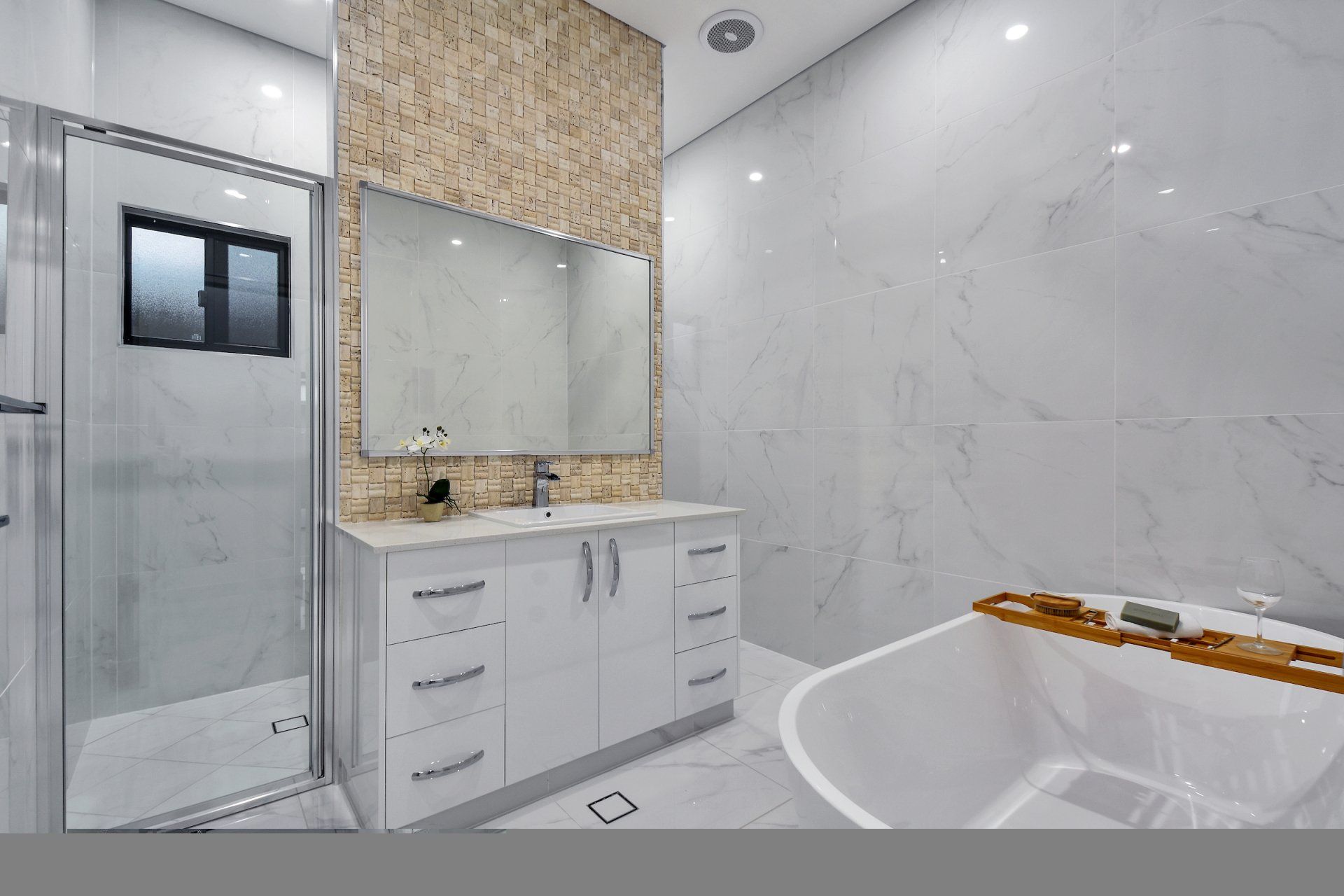 A bathroom with a tub , sink , mirror and shower.