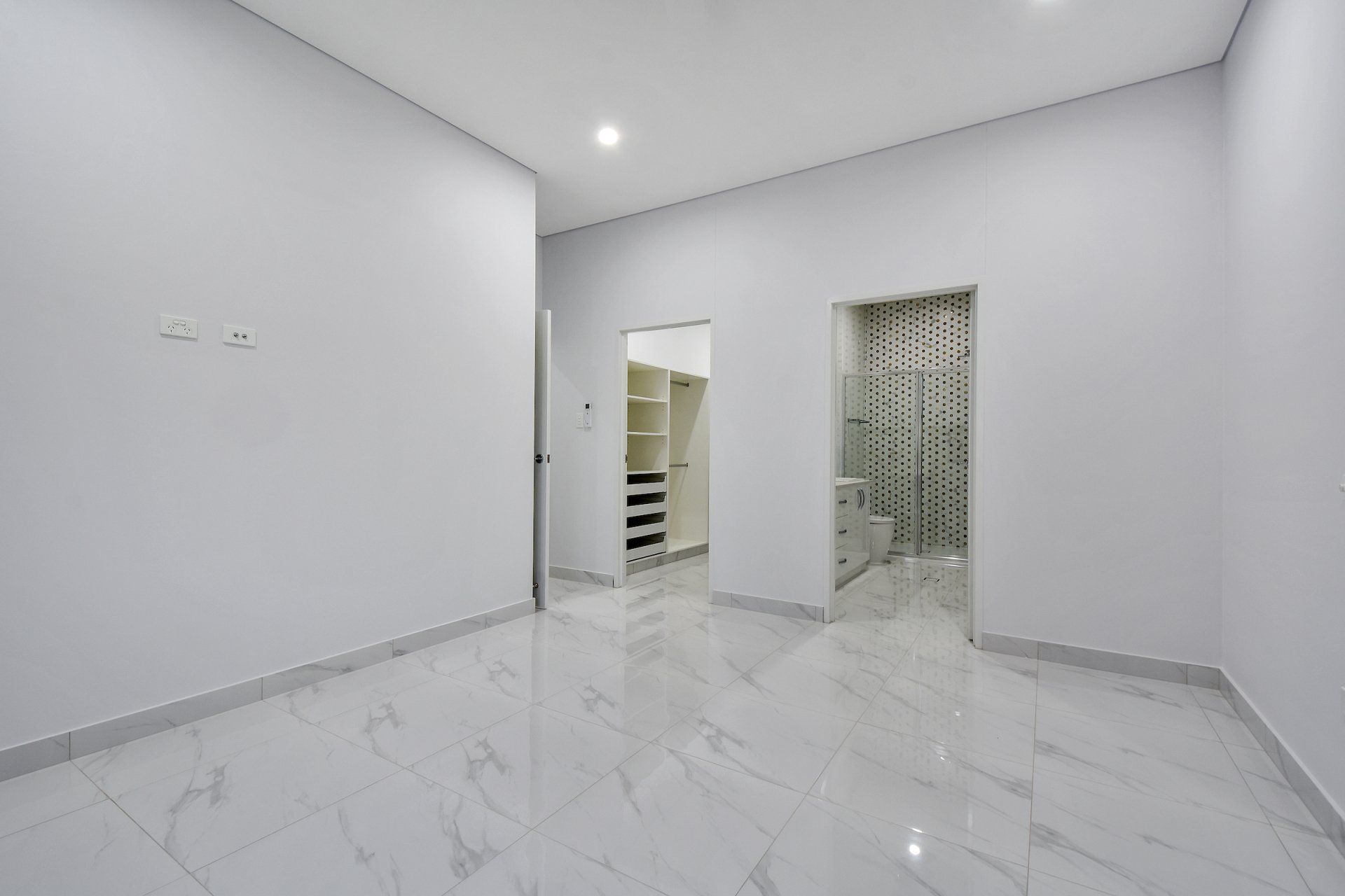 An empty room with a walk in closet and a bathroom.