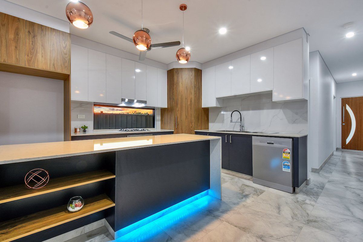 A kitchen with a large island and a ceiling fan.