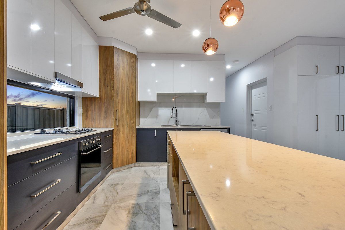 A kitchen with a large island and a ceiling fan.