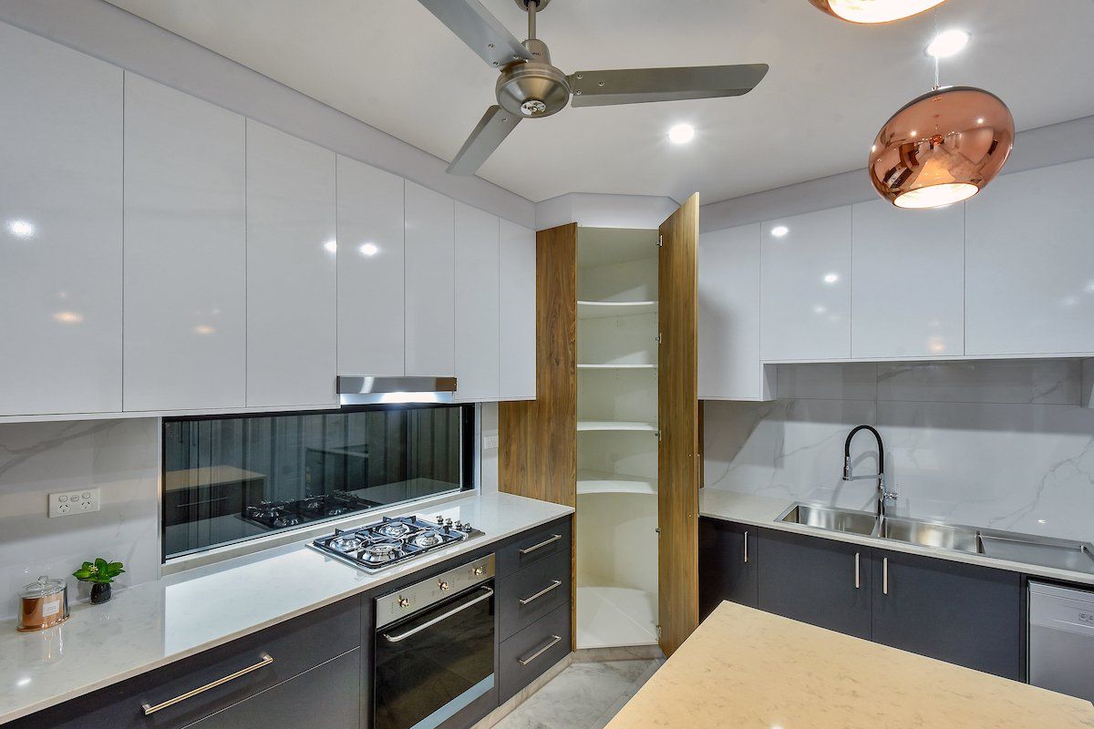 A kitchen with white cabinets and a ceiling fan