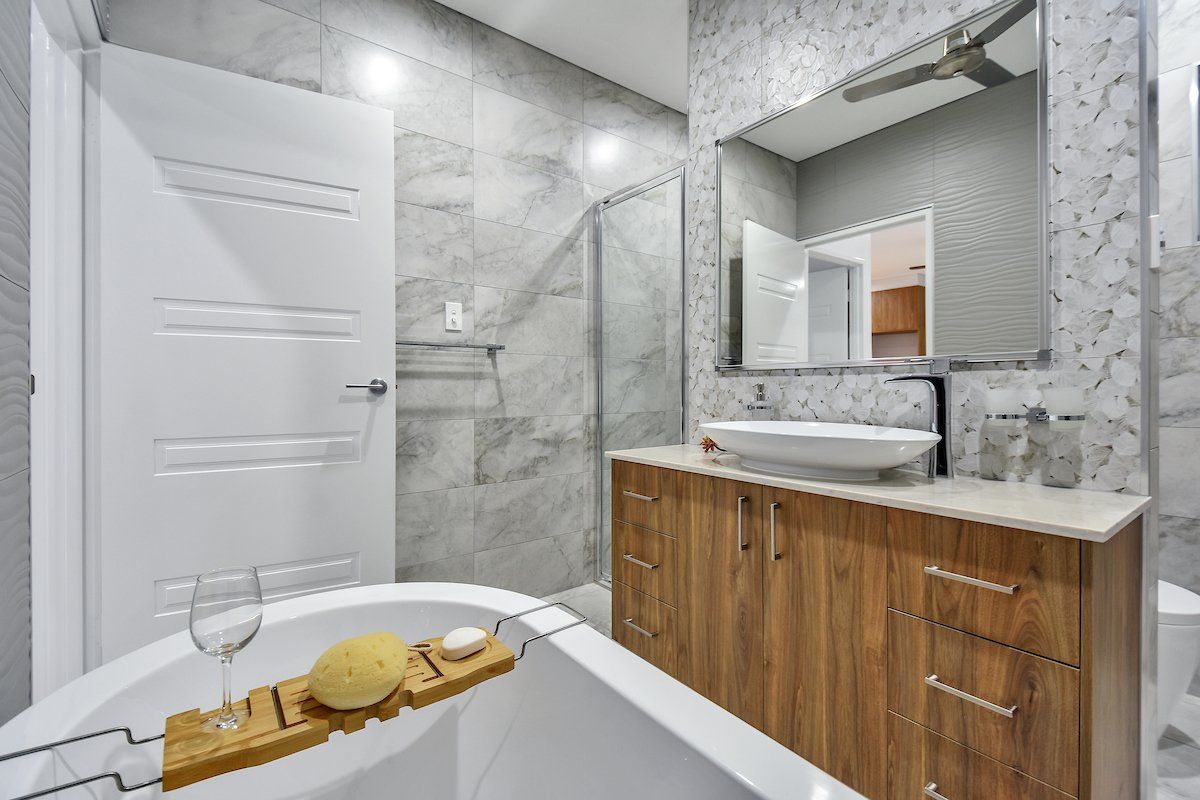 A bathroom with a bathtub , sink , mirror and walk in shower.