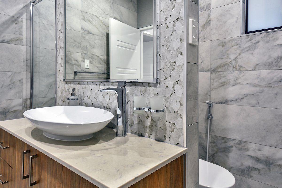 A bathroom with a sink , toilet and mirror.