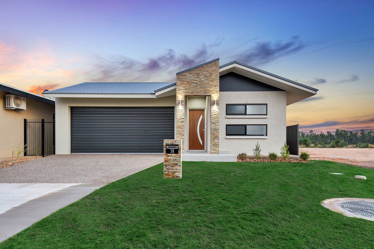 A modern house with a large lawn in front of it.