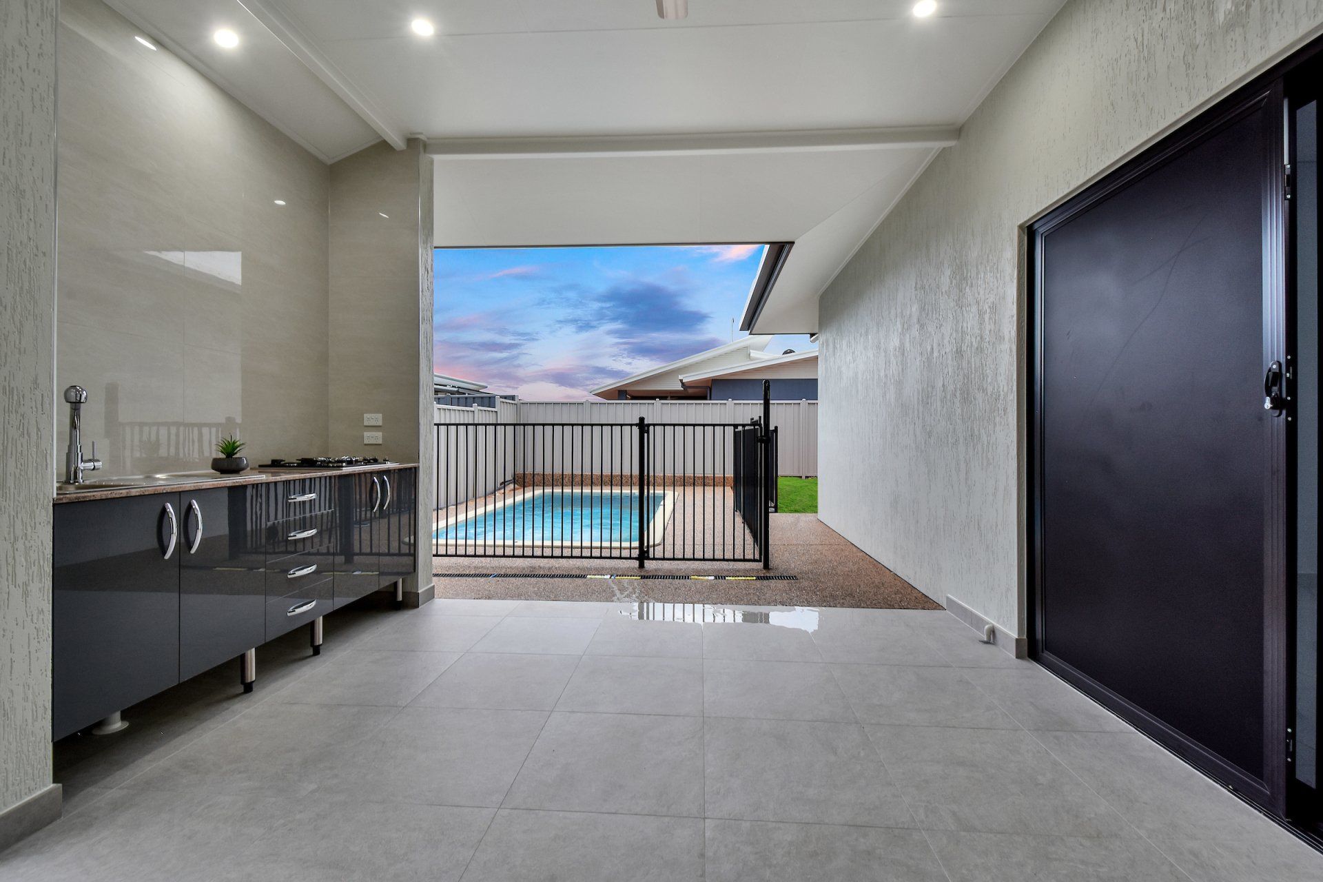 There is a swimming pool in the backyard of a house.