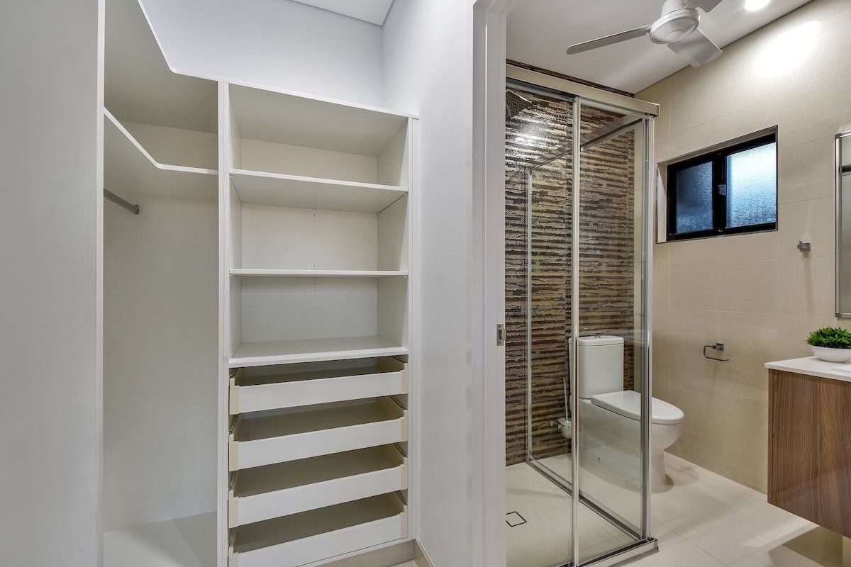 A bathroom with a toilet and a walk in closet