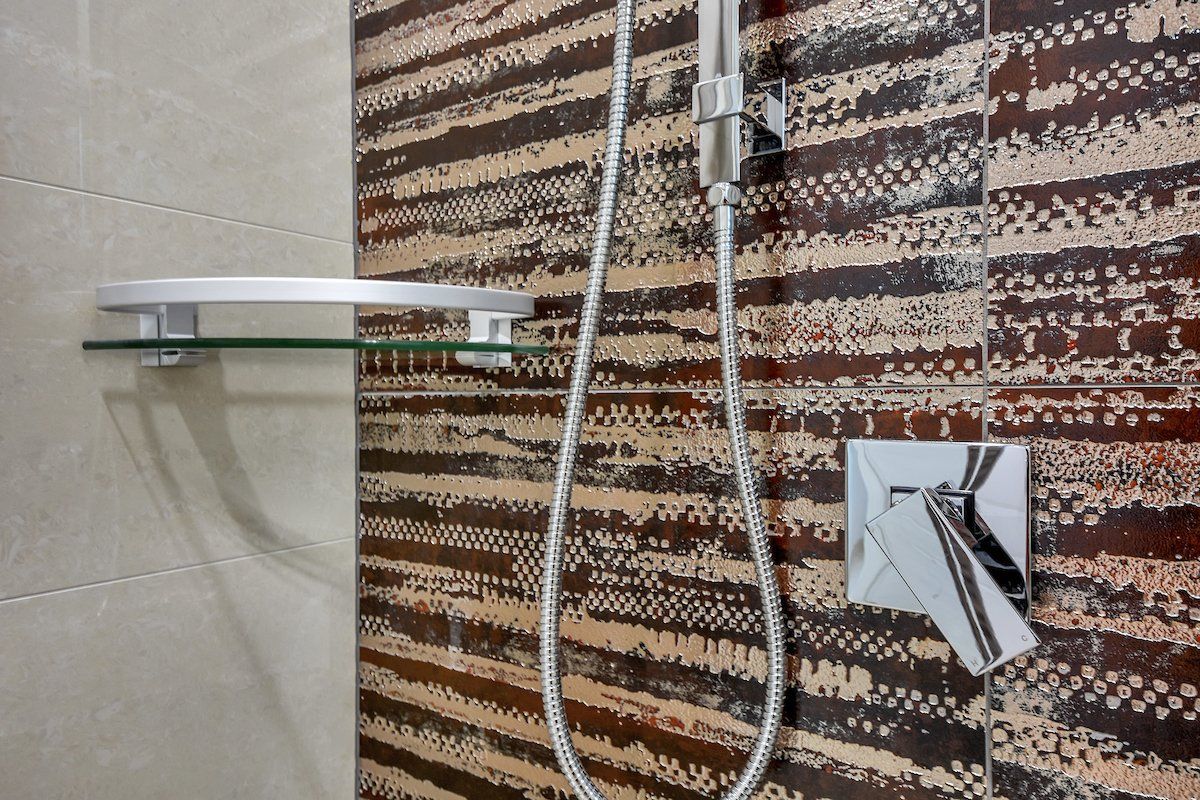 A close up of a shower head in a bathroom