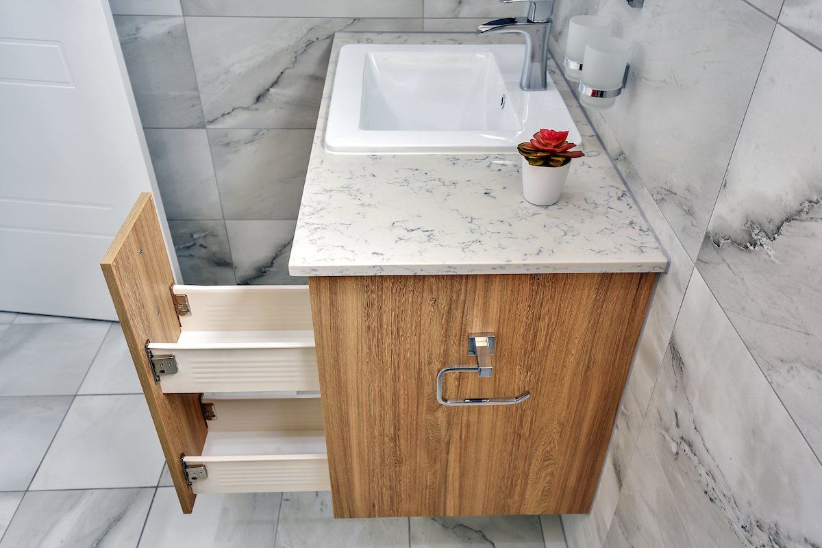 A bathroom vanity with drawers open and a sink.