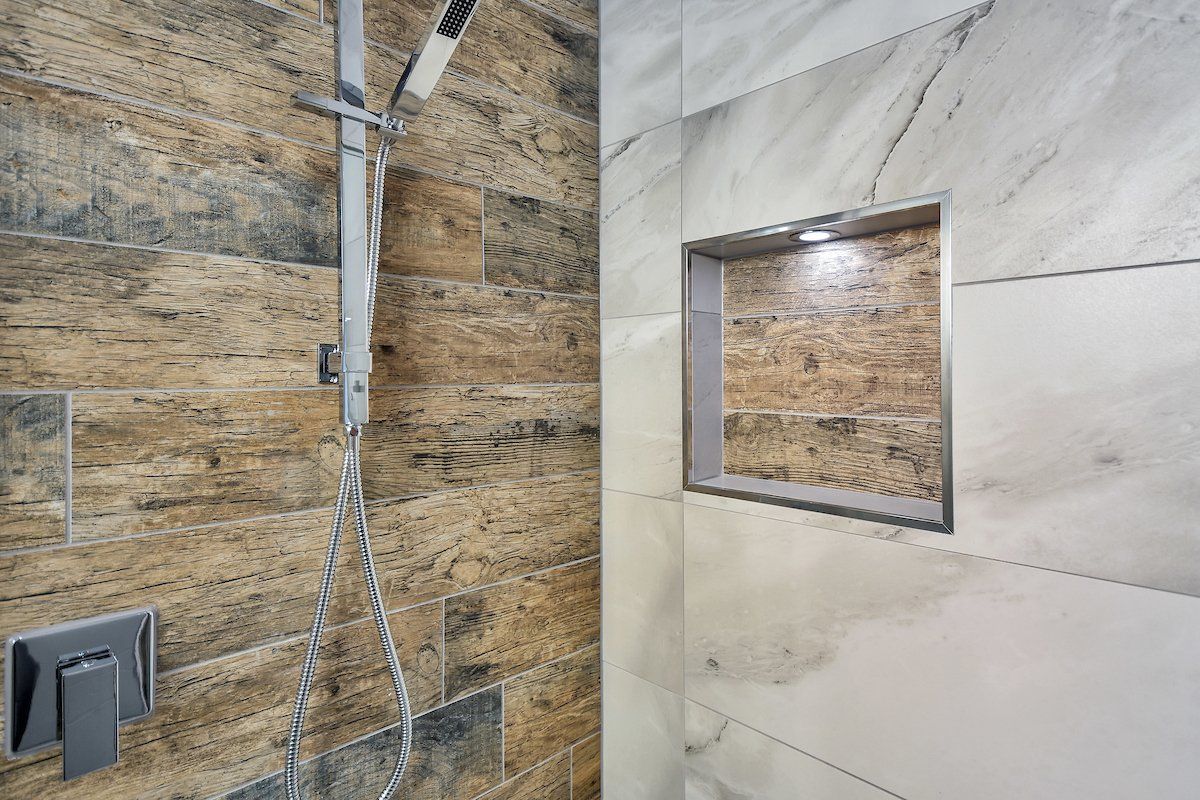 A shower with a shower head and a niche in the wall.