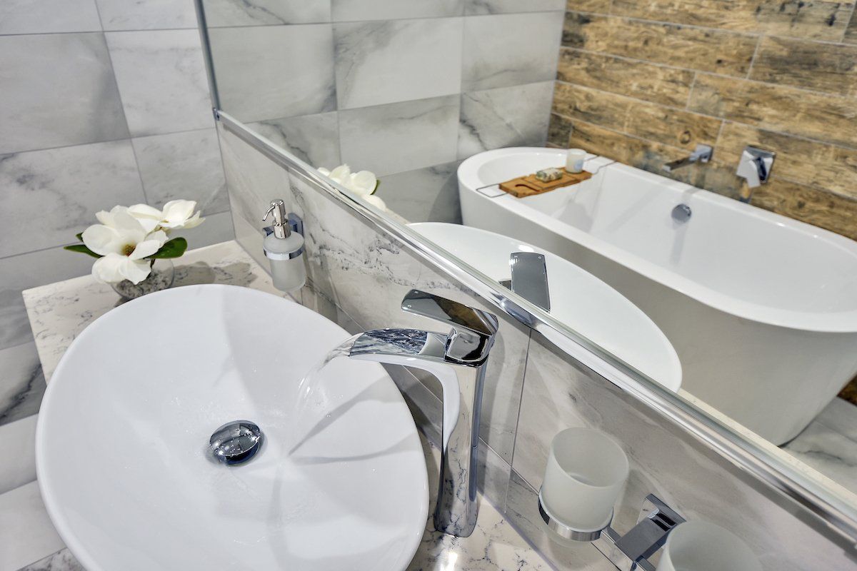 A bathroom with a sink , bathtub and mirror.