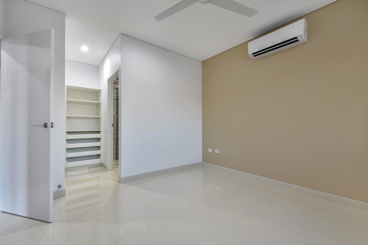 An empty room with a ceiling fan and a closet.