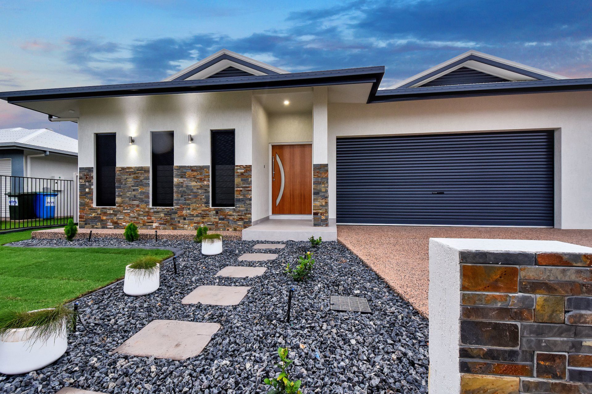 A large white house with a black garage door