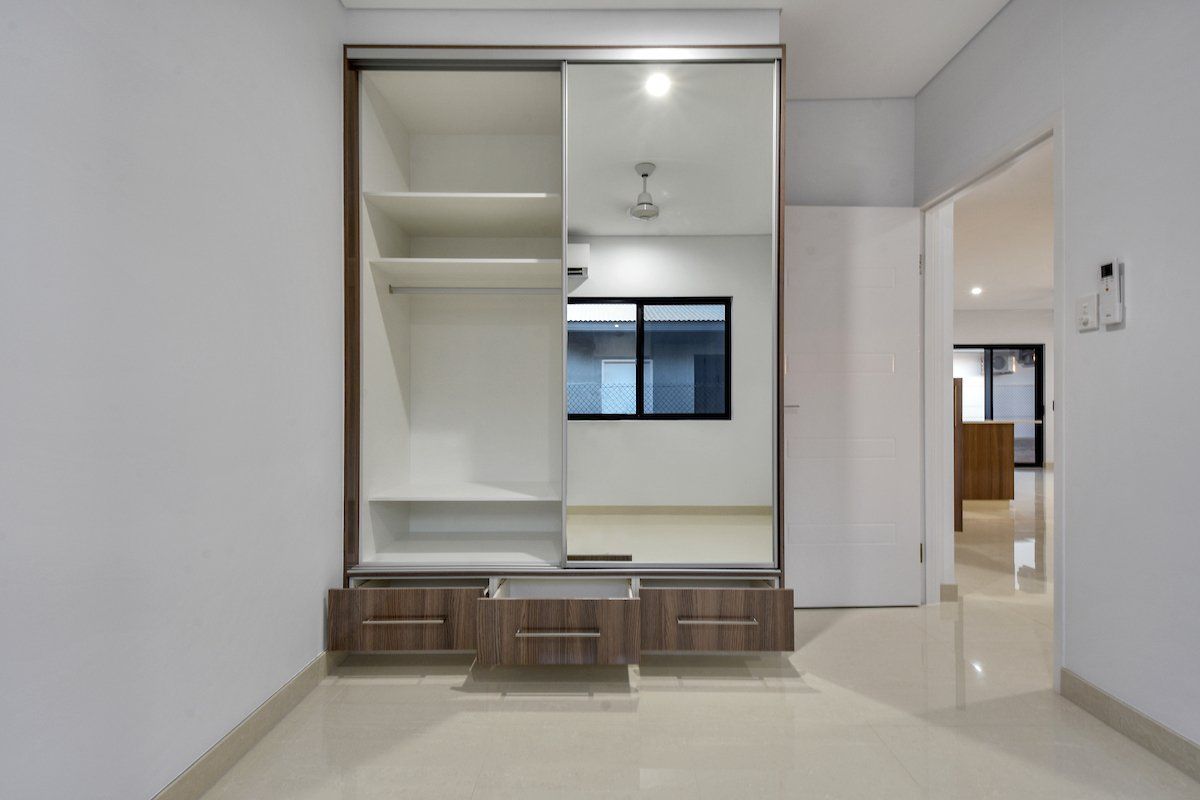 An empty room with a wardrobe and a window