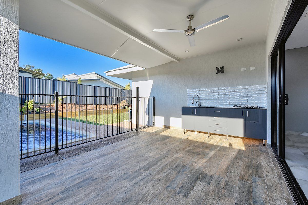 There is a ceiling fan on the balcony of a house.