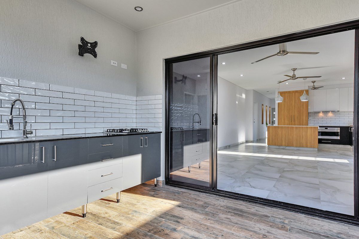 A kitchen with a sliding glass door leading to a patio.