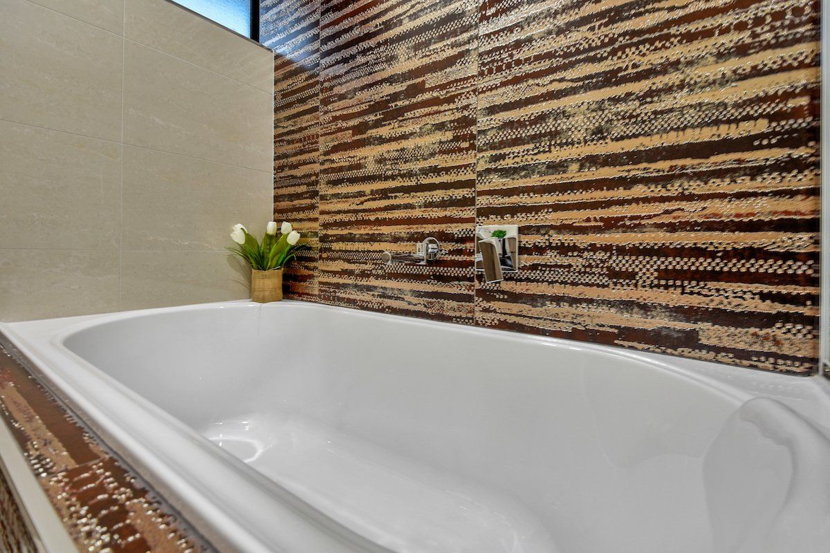 A bathtub in a bathroom with a wooden wall behind it.
