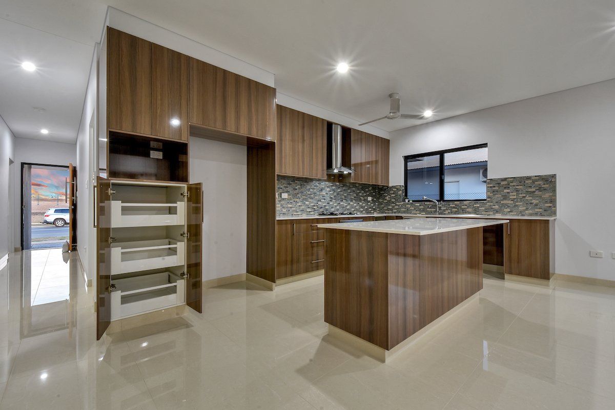 An empty kitchen with wooden cabinets and a large island.