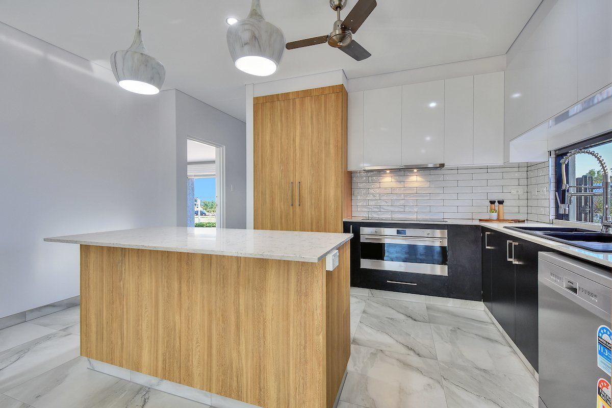 A kitchen with a large island and a ceiling fan