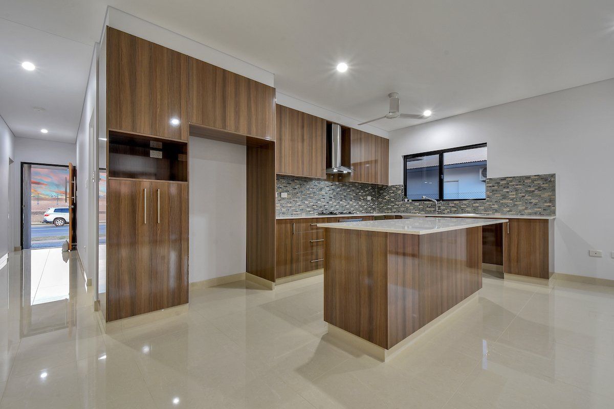 A kitchen with wooden cabinets and a large island in a house.