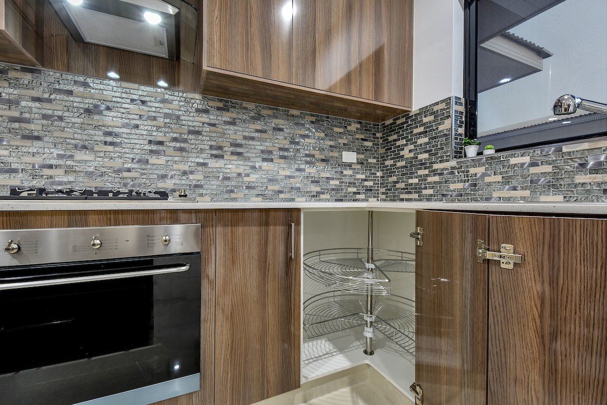 A kitchen with wooden cabinets , stainless steel appliances , a stove and a sink.