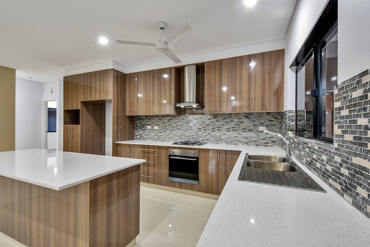 A kitchen with wooden cabinets and white counter tops