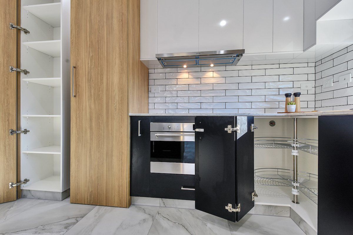 A kitchen with black cabinets and stainless steel appliances