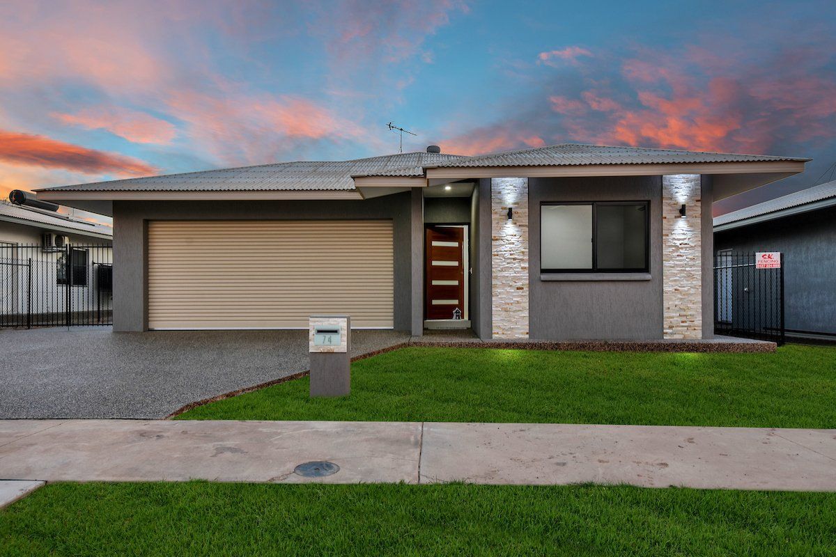 A house with a garage and a fence in front of it.