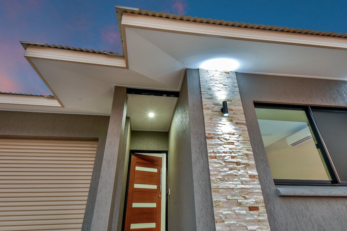 The front of a house with a brick wall and a garage door