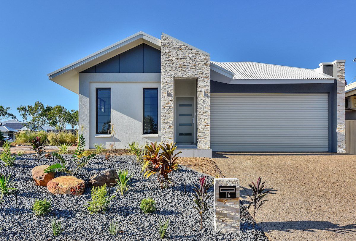 A modern house with a garage and a mailbox in front of it.