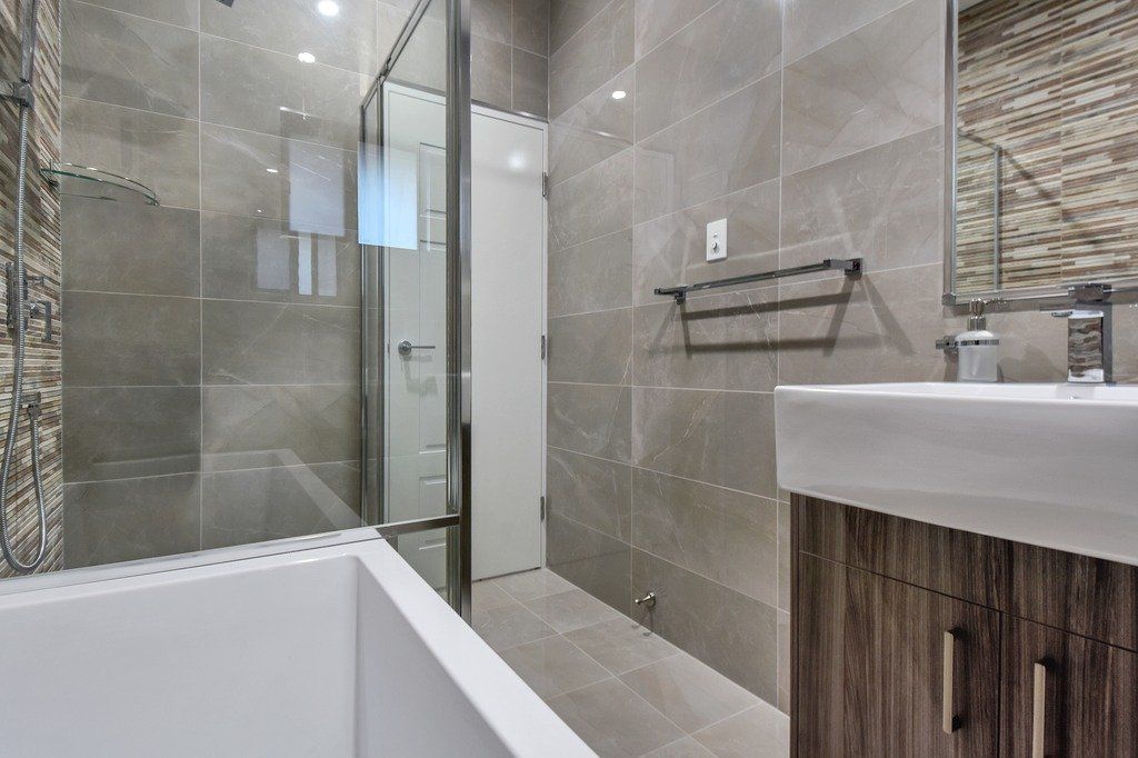 A bathroom with a bathtub , sink , and walk in shower.