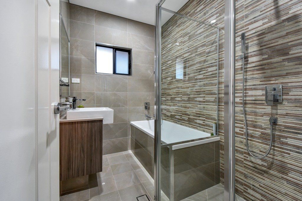 A bathroom with a tub , sink and shower.