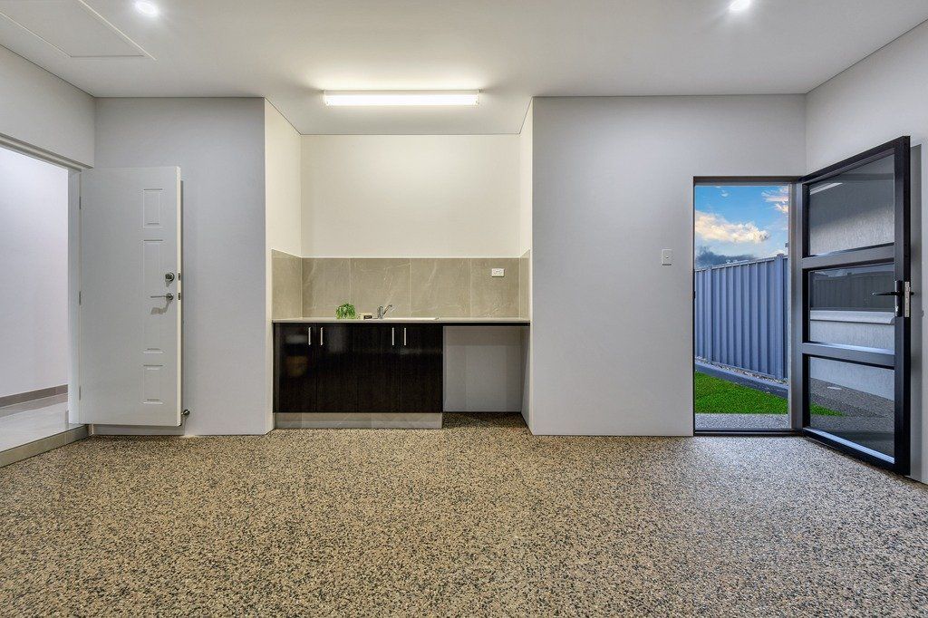 An empty garage with a kitchen and a door.
