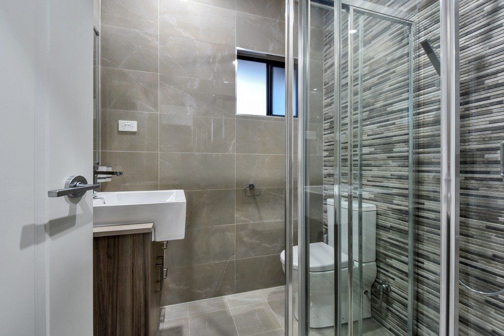 A bathroom with a toilet , sink and shower stall.