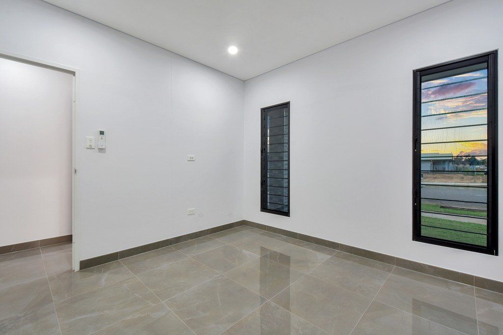 An empty room with two windows and a marble floor.