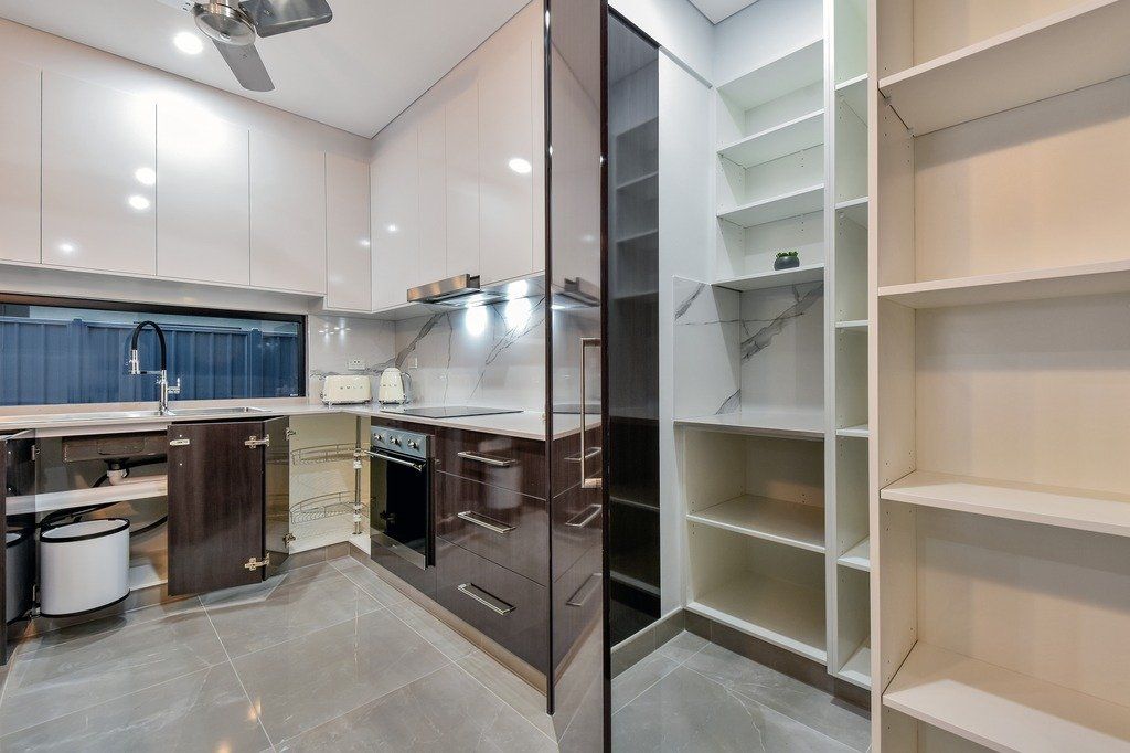 A kitchen with a lot of shelves and a ceiling fan