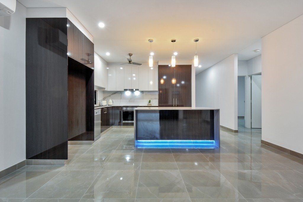 An empty kitchen with a large island in the middle of the room.
