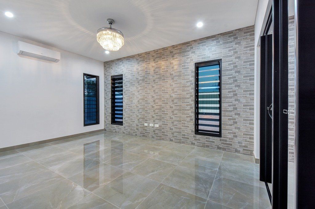A large empty room with a ceiling fan and a chandelier.