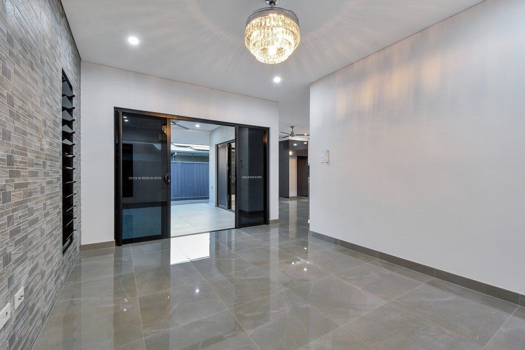 A large empty room with a chandelier hanging from the ceiling.