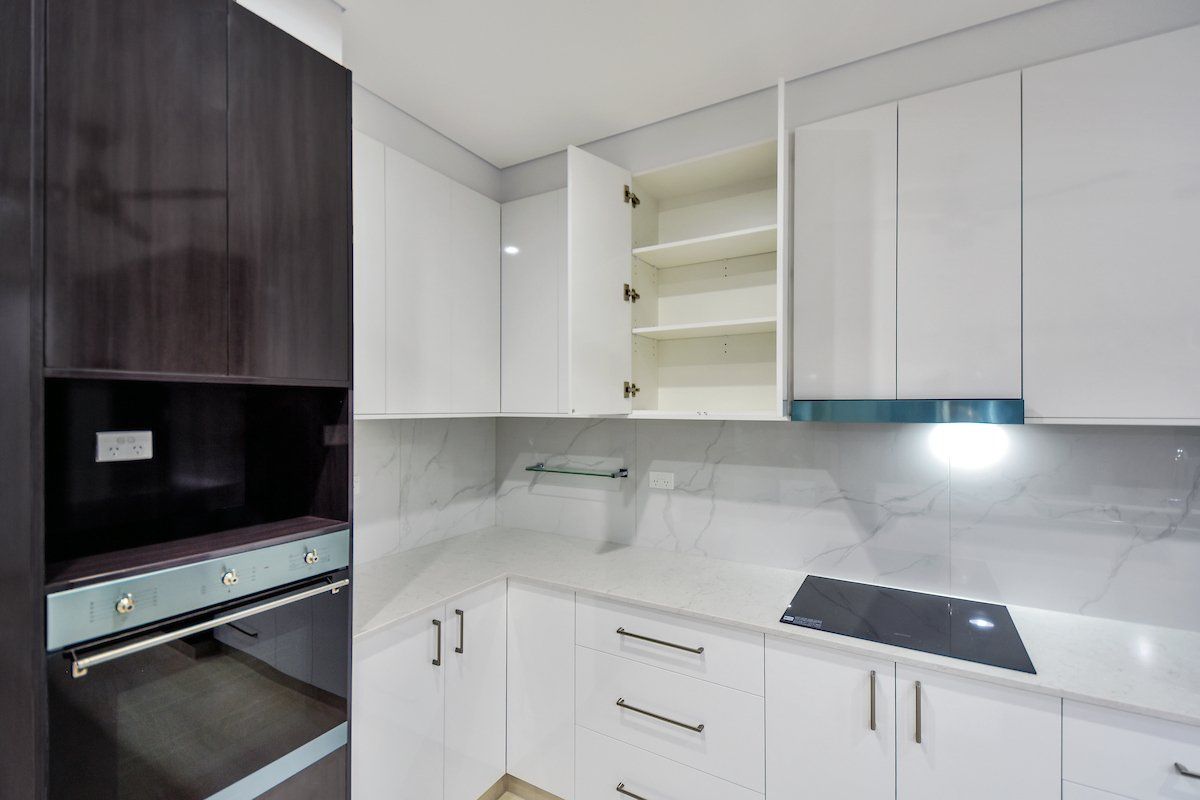 A kitchen with white cabinets and a black stove top oven