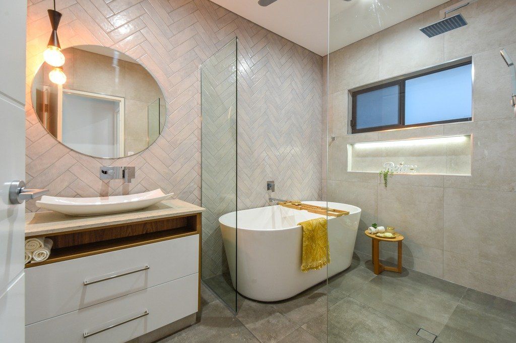 A bathroom with a tub , sink , mirror and walk in shower.