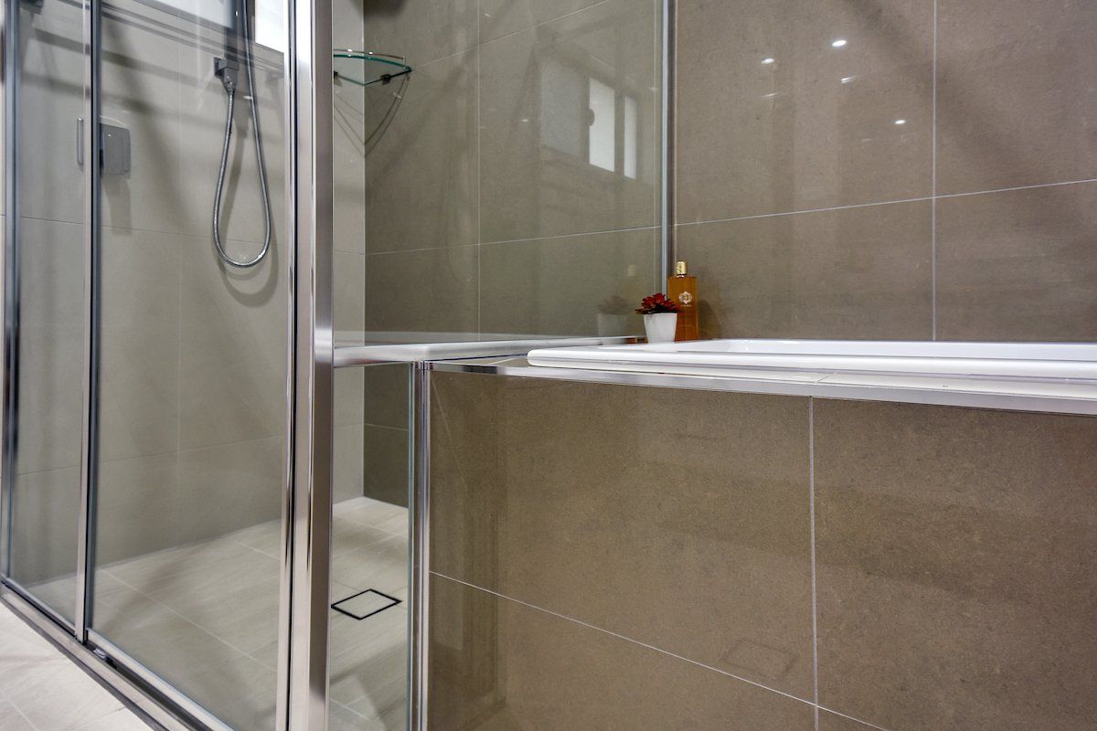 A bathroom with a walk in shower and a bathtub.